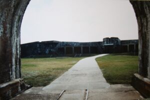 Path through a brick archway leading toward the walls of historic Fort Morgan near Gulf Shores, Alabama