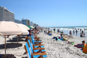 Busy summer beach with rows of umbrellas and beach chairs along the Atlantic shoreline near Myrtle Beach, South Carolina