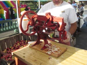Vintage red apple paring machine and crates of apples at Fly Creek Cider Mill near Cooperstown, New York, in October