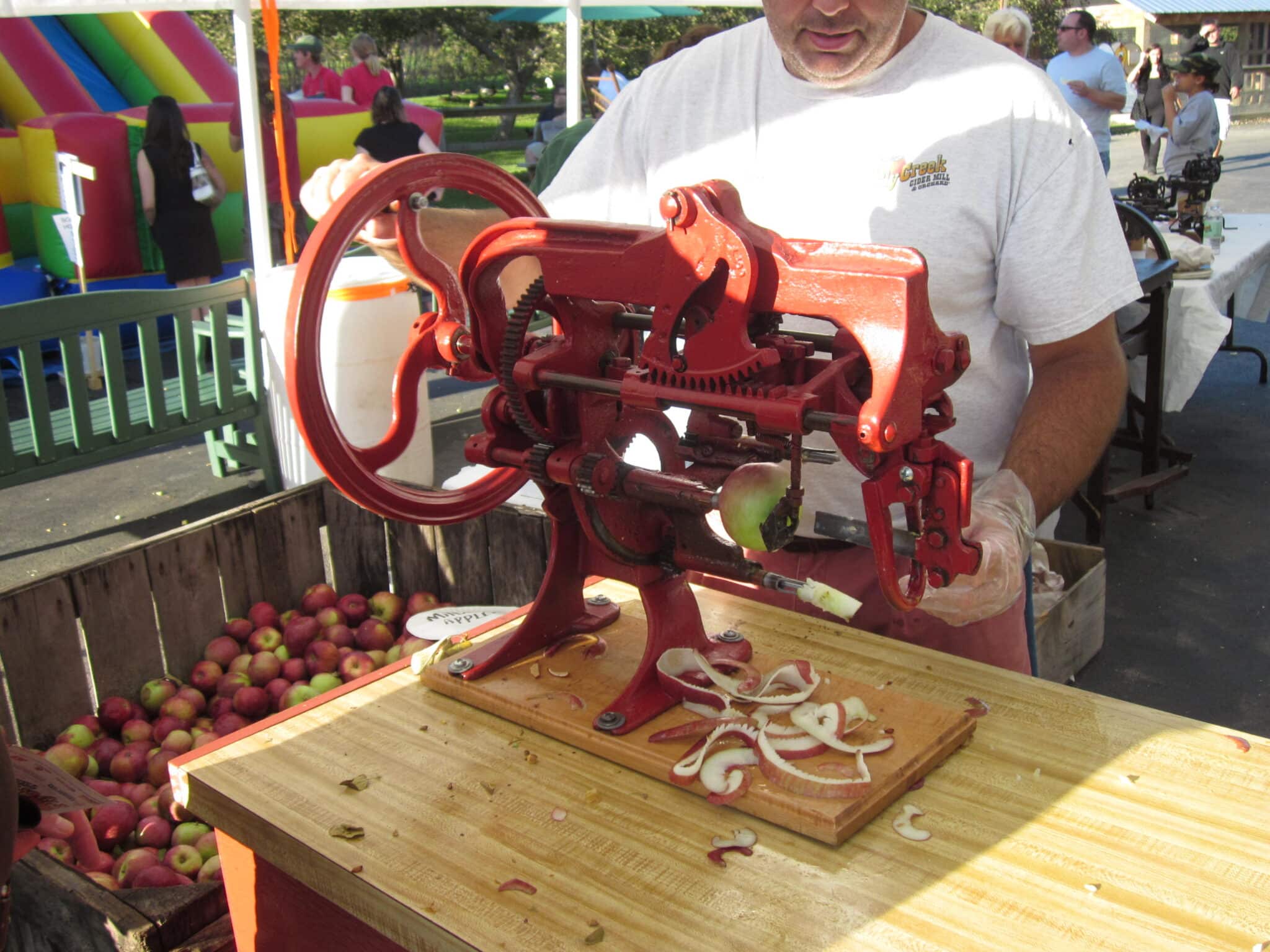 Vintage red apple paring machine and crates of apples at Fly Creek Cider Mill near Cooperstown, New York, in October